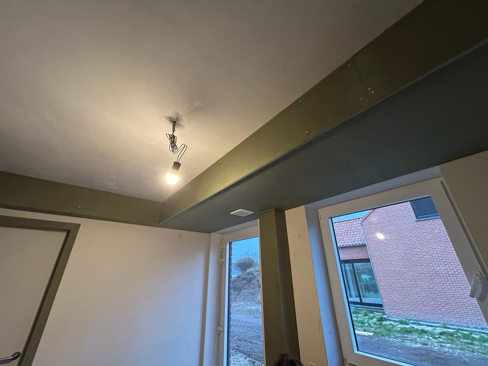 Afgewerkte inkomhal met gyprocplafond en nieuwe deuromlijstingen in Hille