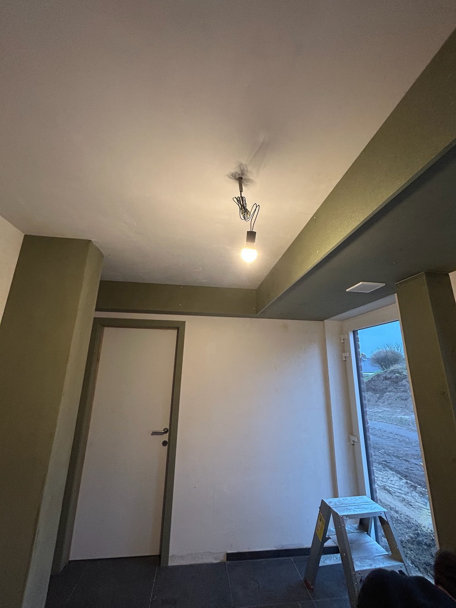 Afgewerkte inkomhal met gyprocplafond, deur en omlijsting in Hille