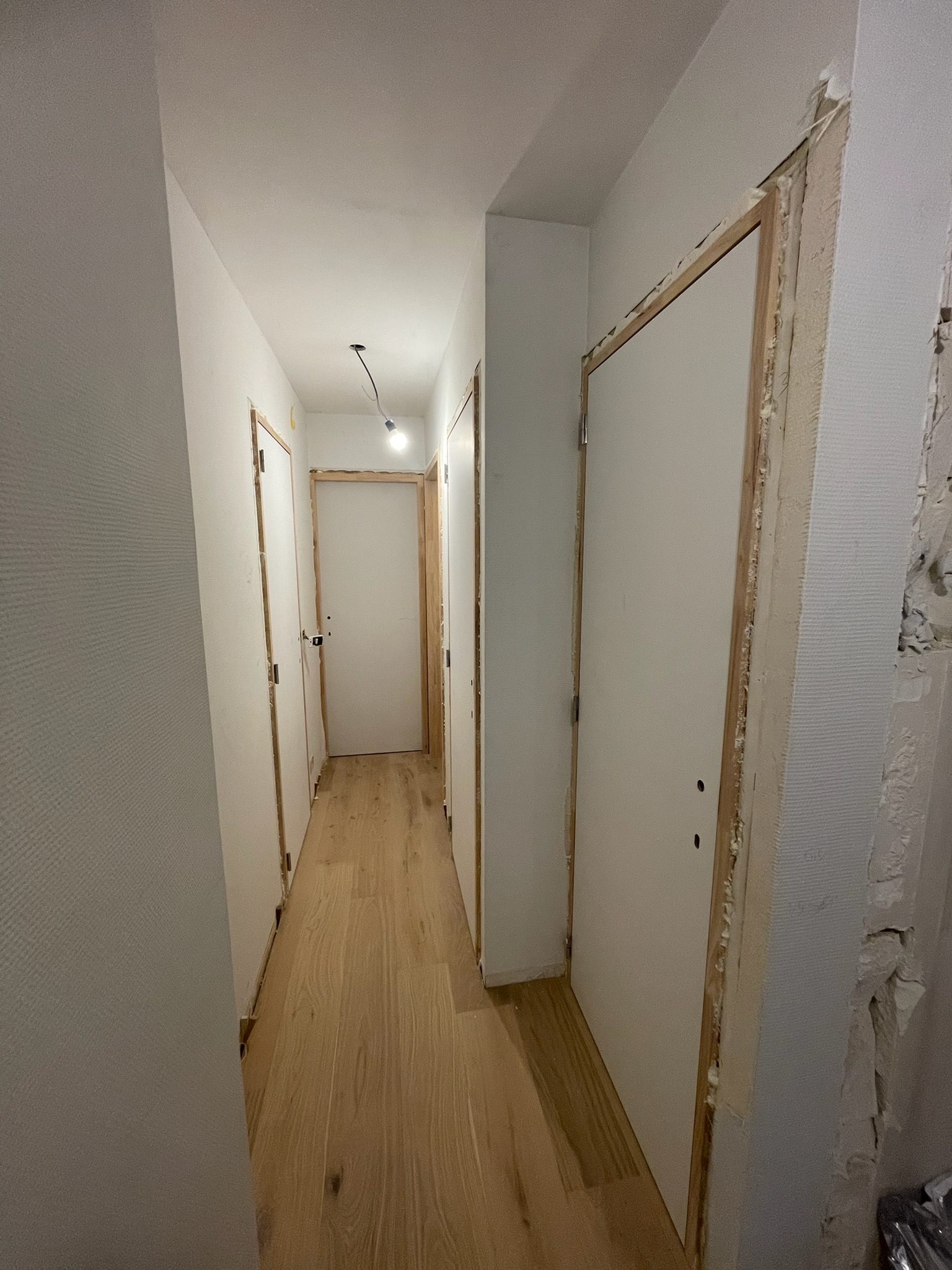 Gang met nieuwe binnendeuren en eiken parket in Knokke-Heist