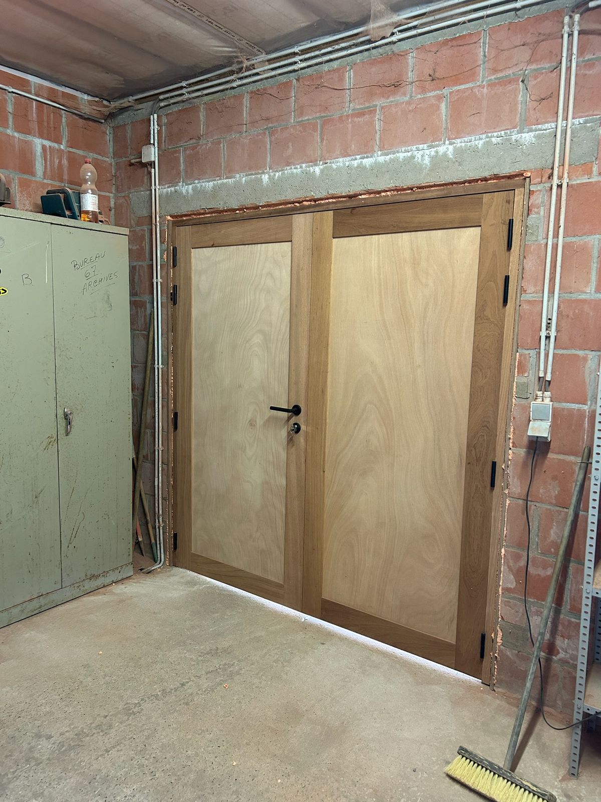 Binnenzijde van een dubbele houten poort in een bakstenen schuur in Poesele.