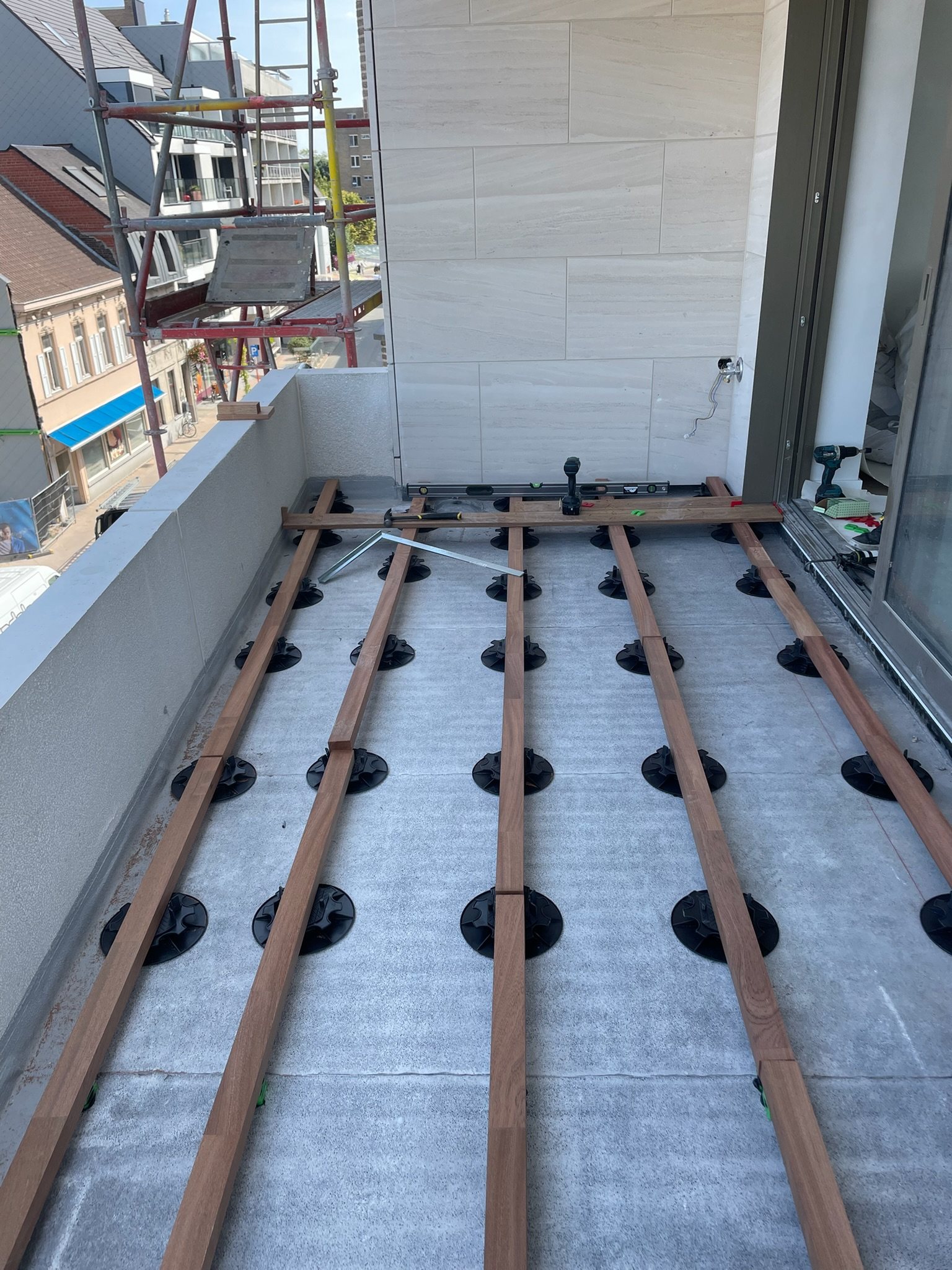 Hardhouten onderstructuur op regelbare tegeldragers voor een dakterras in Deinze
