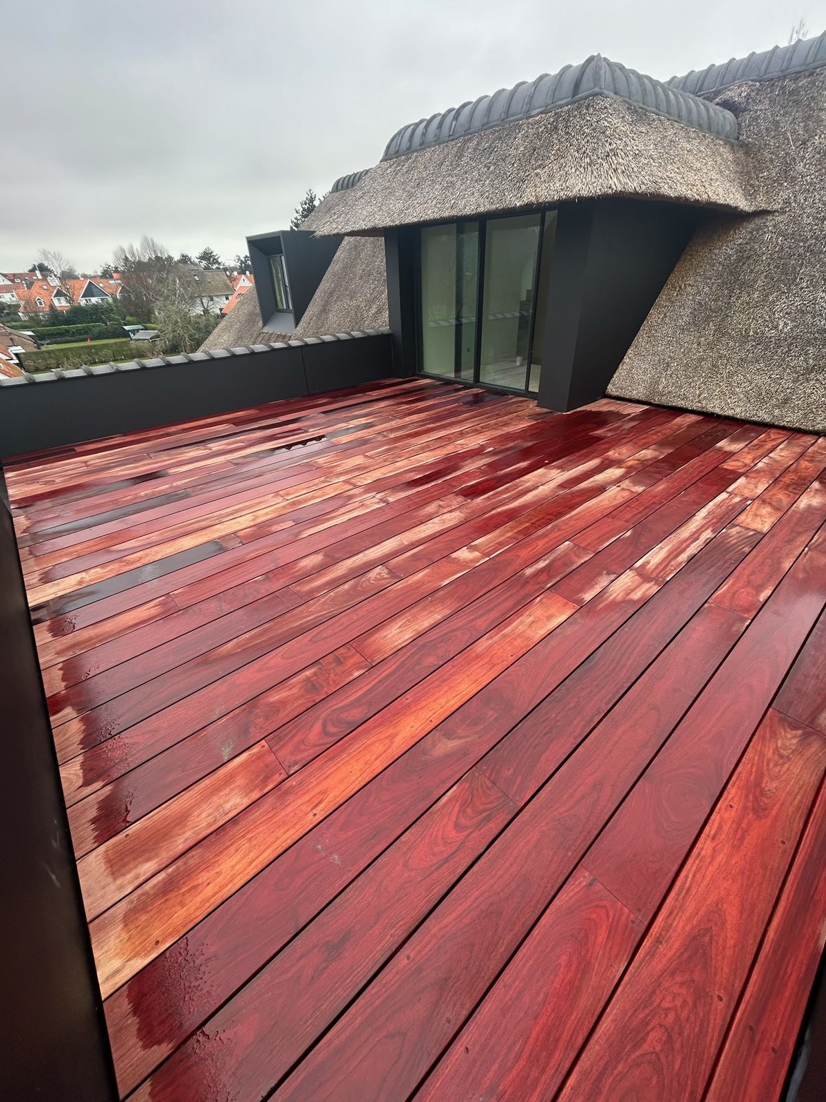 Hardhouten dakterras naast een rieten dak met uitzicht op de omgeving in Knokke-Heist.