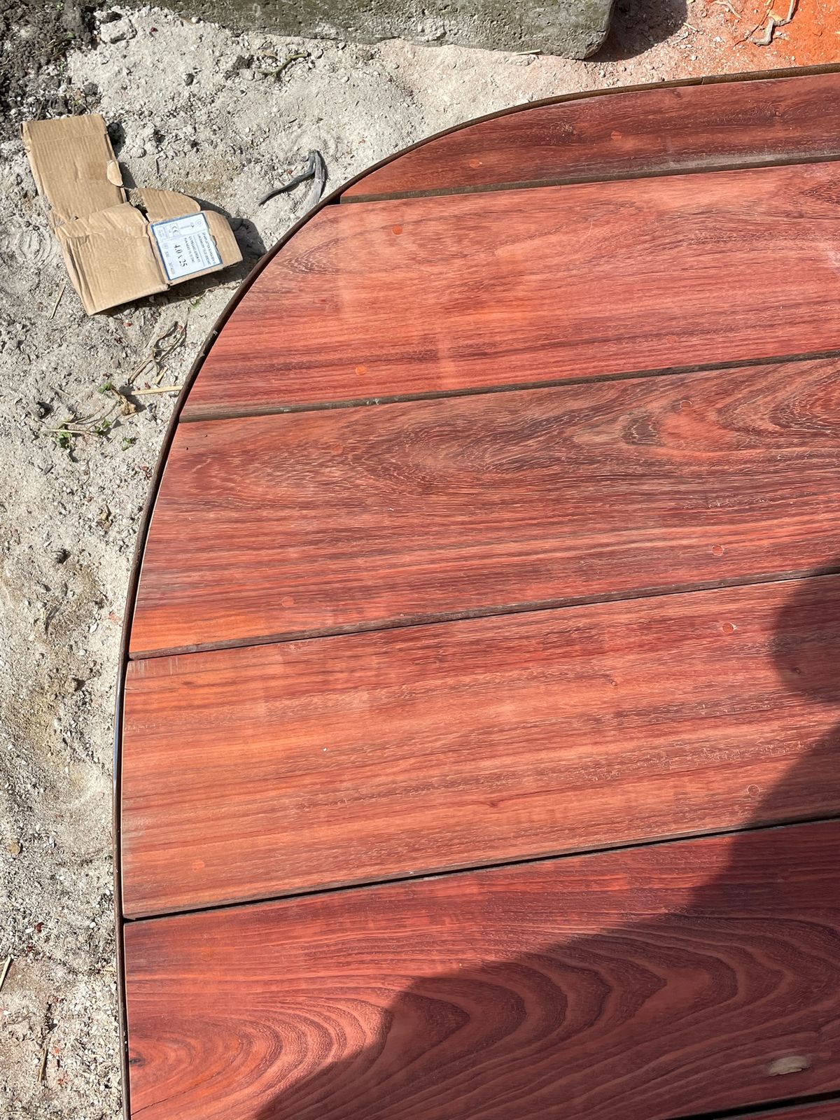 Detail van de afgeronde hoek van een hardhouten terras met gebogen boord in Knokke-Heist.