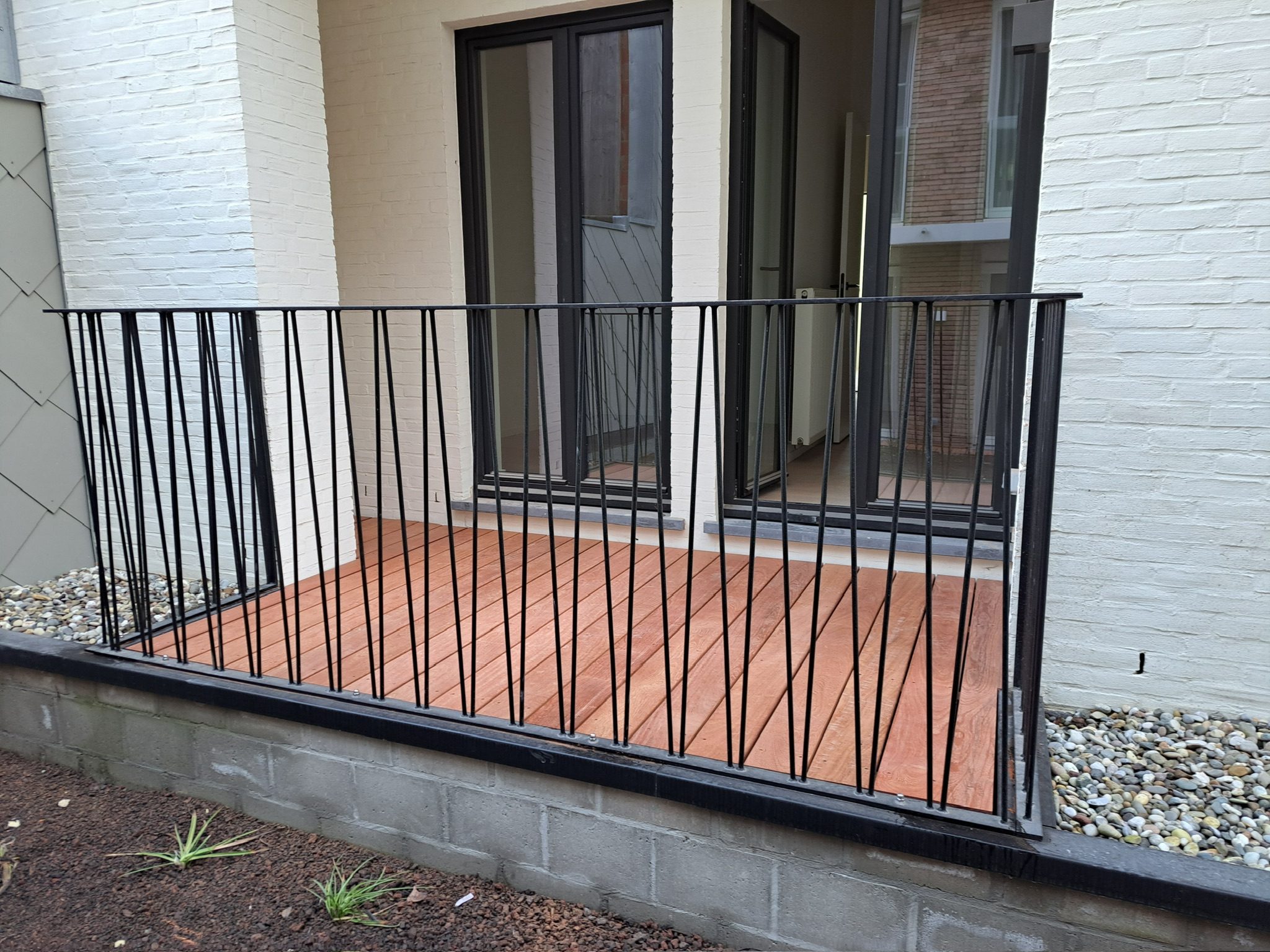 Hardhouten terras met zwarte balustrade in Gent