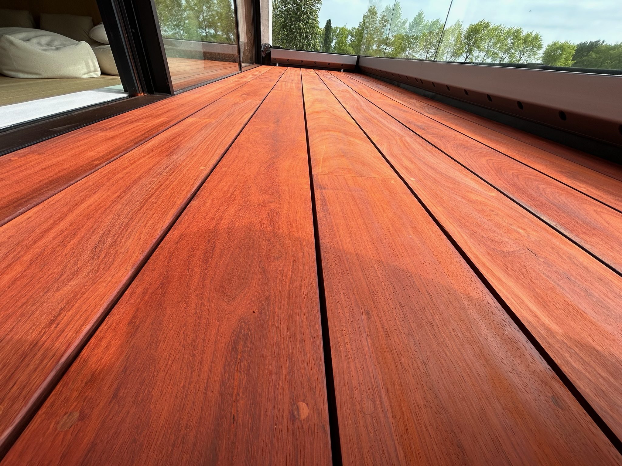 Detail van een rood hardhouten terras met strakke voegen in Oostkerke