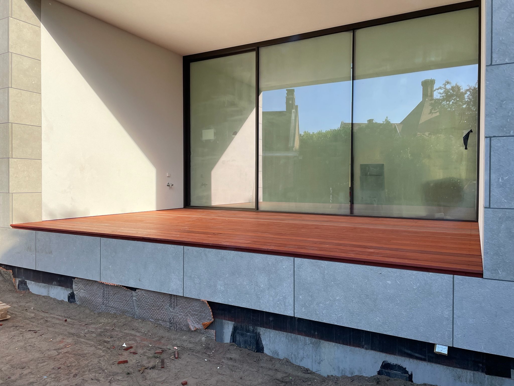 Hardhouten terras langs een glazen pui in Gent