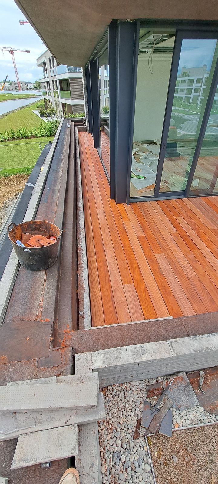 Hardhouten terras in aanleg langs een glazen gevel van een woning in Sterrebeek.