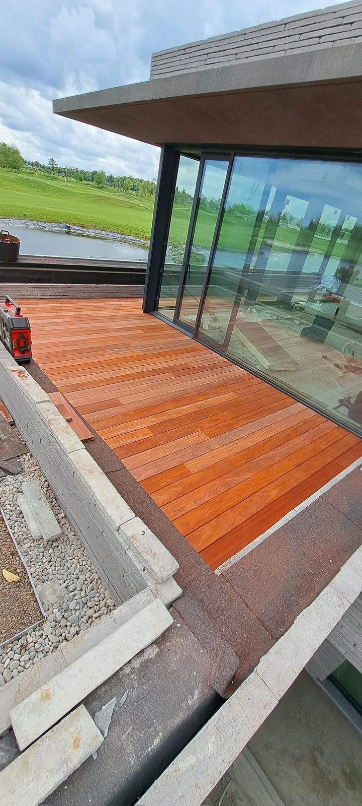 Hardhouten terras voor grote schuiframen met zicht op de velden in Sterrebeek.