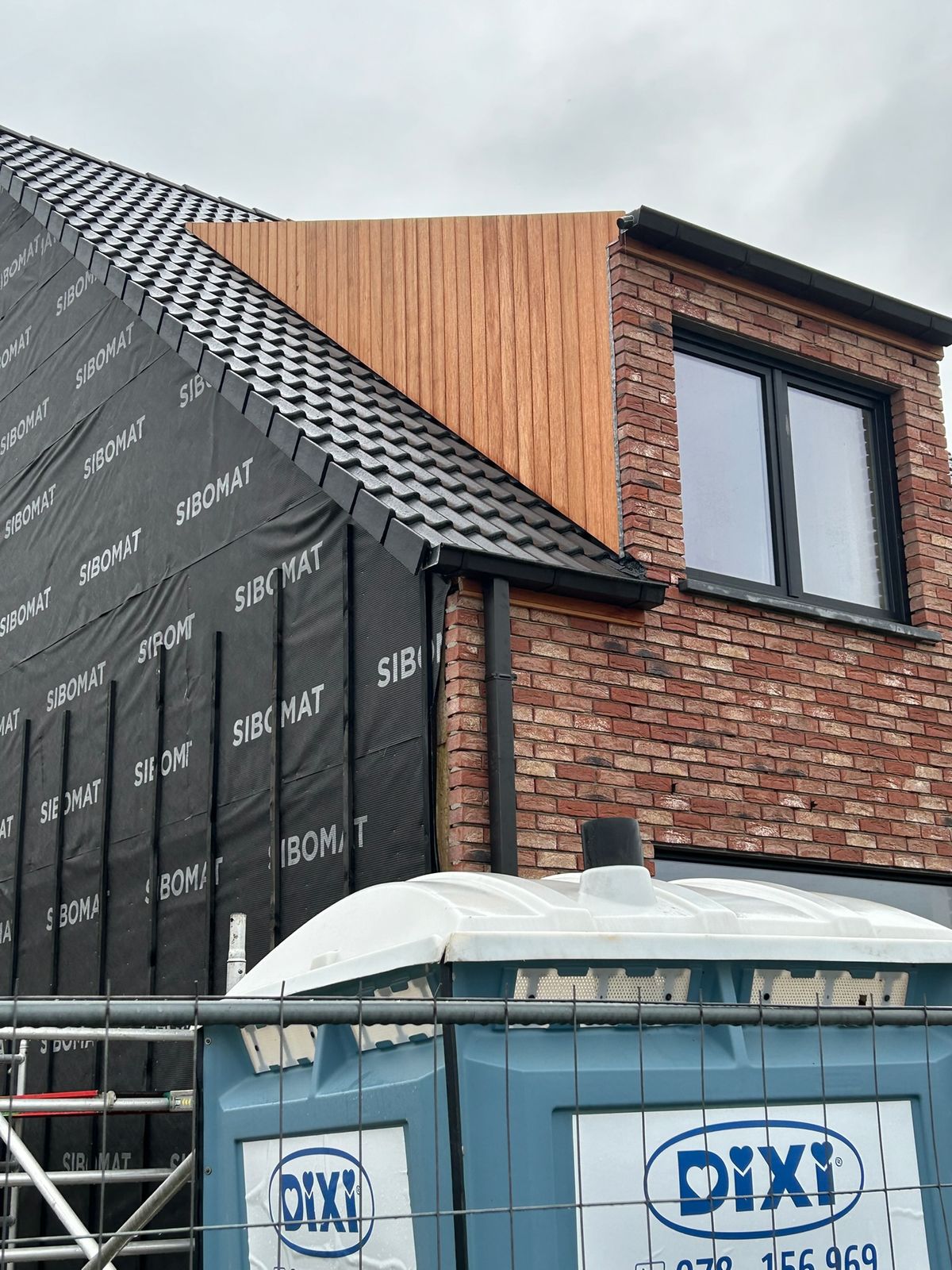 Verticale houten bekleding op de zijkant van een dakkapel tijdens de werf in Varsenare.