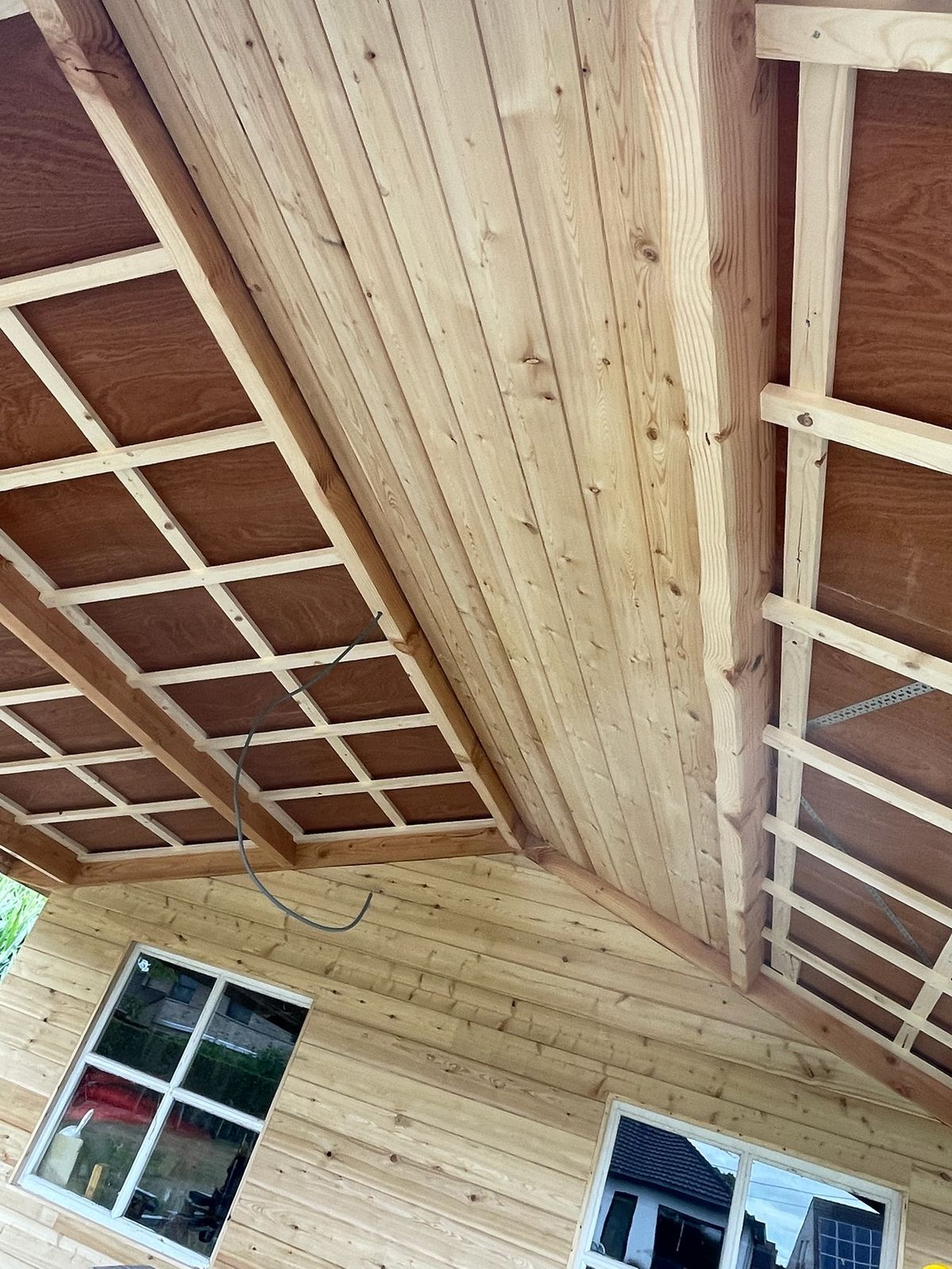 Houten plafond en dakopbouw van een poolhouse, gezien van binnenuit, in Machelen.