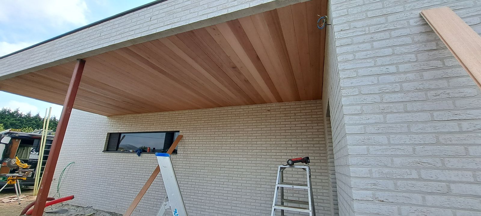 Houten plafond van een overdekt terras tijdens de afwerking bij een woning in Torhout.