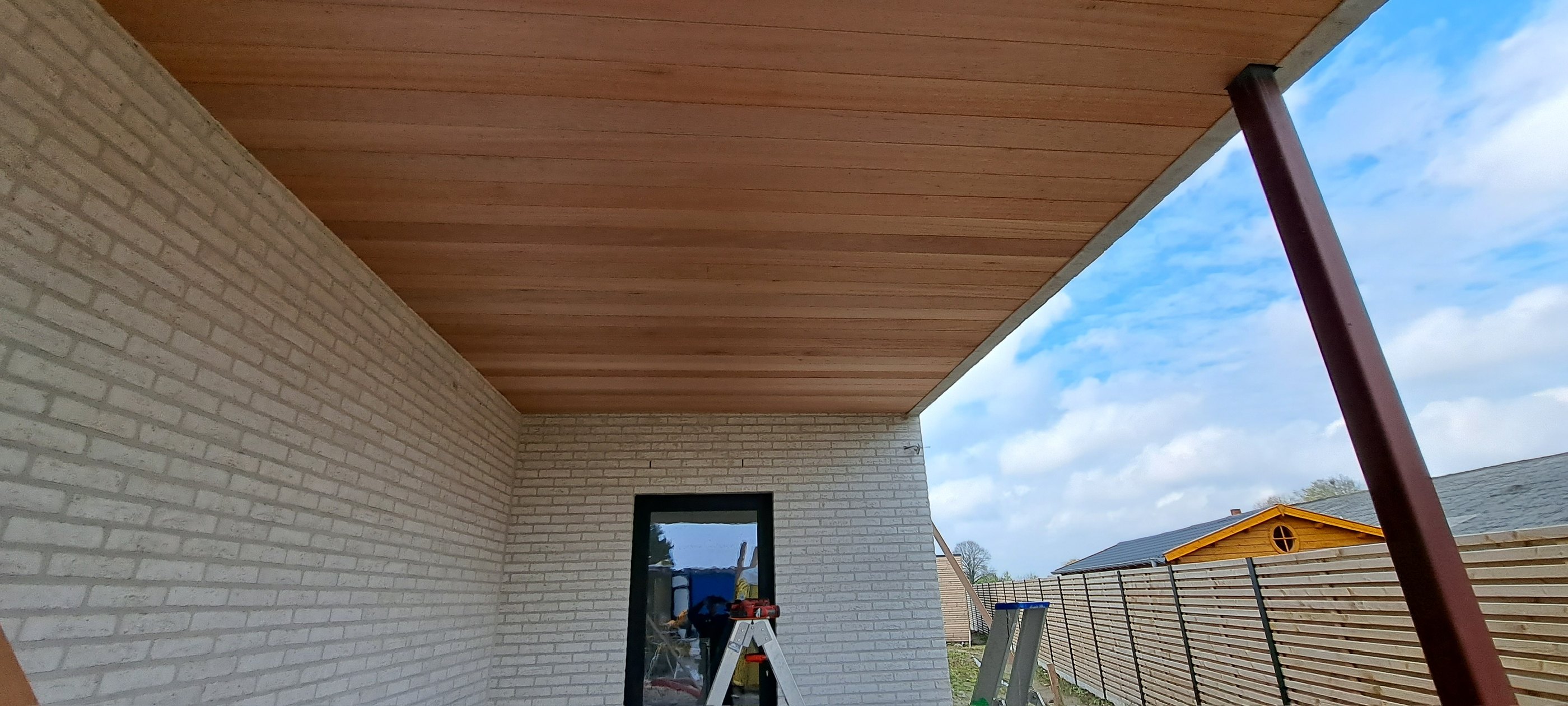Strak houten plafond tussen witte baksteen in Torhout