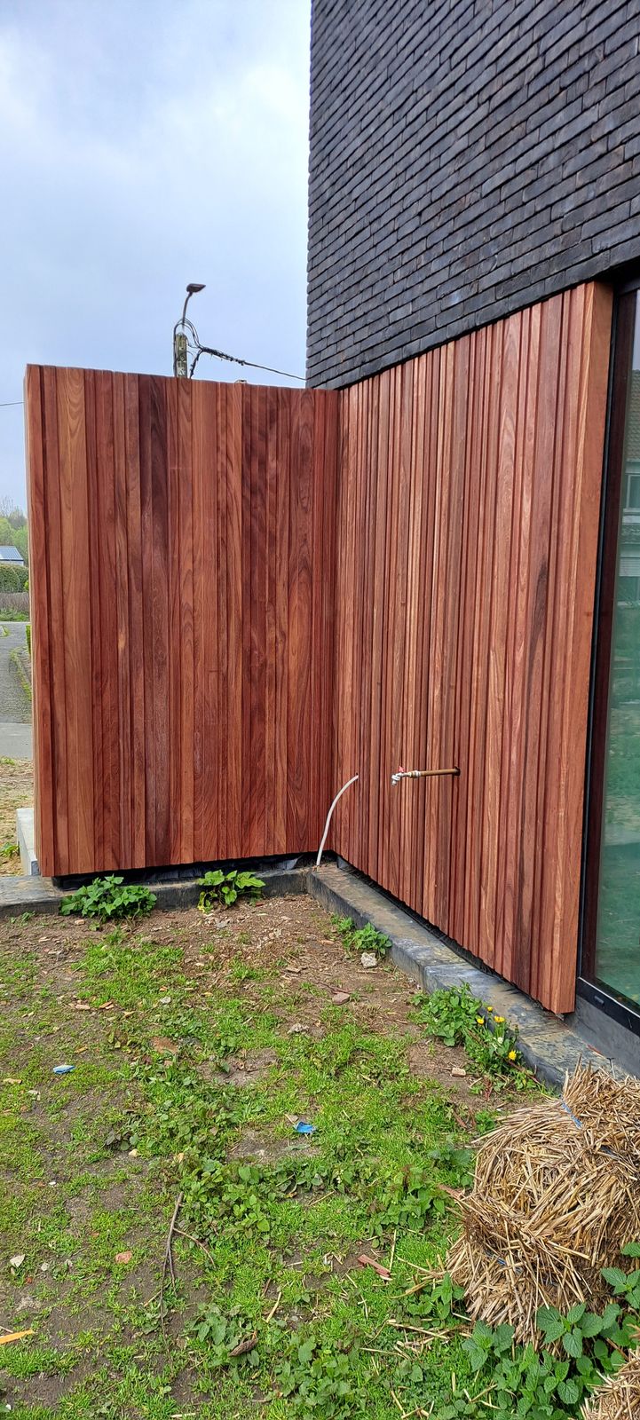 Padoek gevelbekleding in verticale planken rond een binnenhoek van een woning in Wintam.