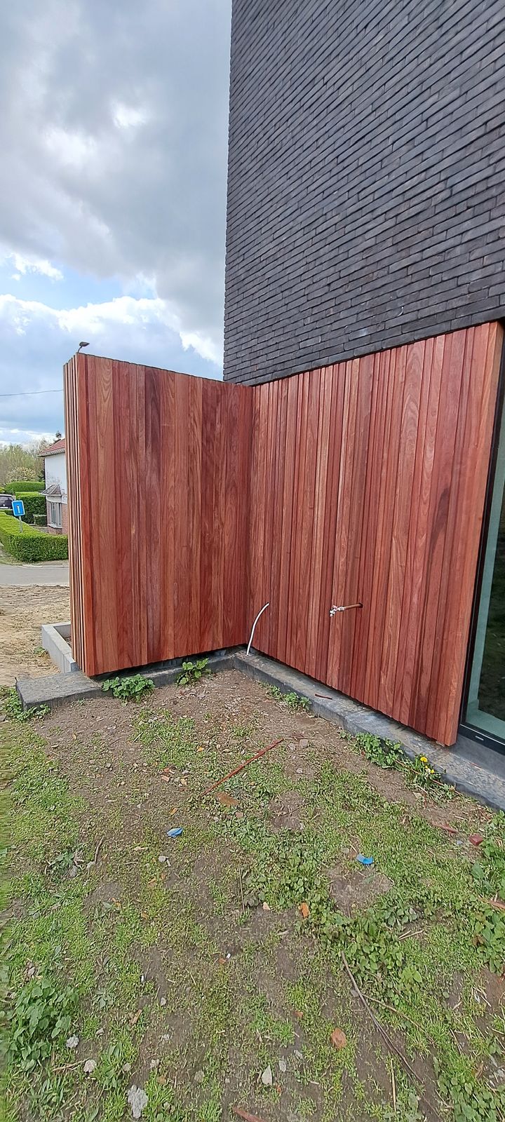 Roodbruine padoek planken als gevelbekleding op de hoek van een moderne woning in Wintam.