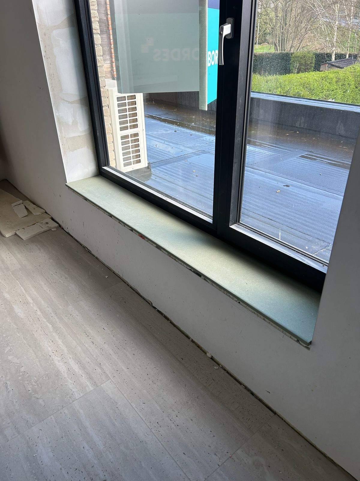 Detail van een geplaatste raamtablet bij een zwart raam in een nieuwbouwwoning in De Pinte.