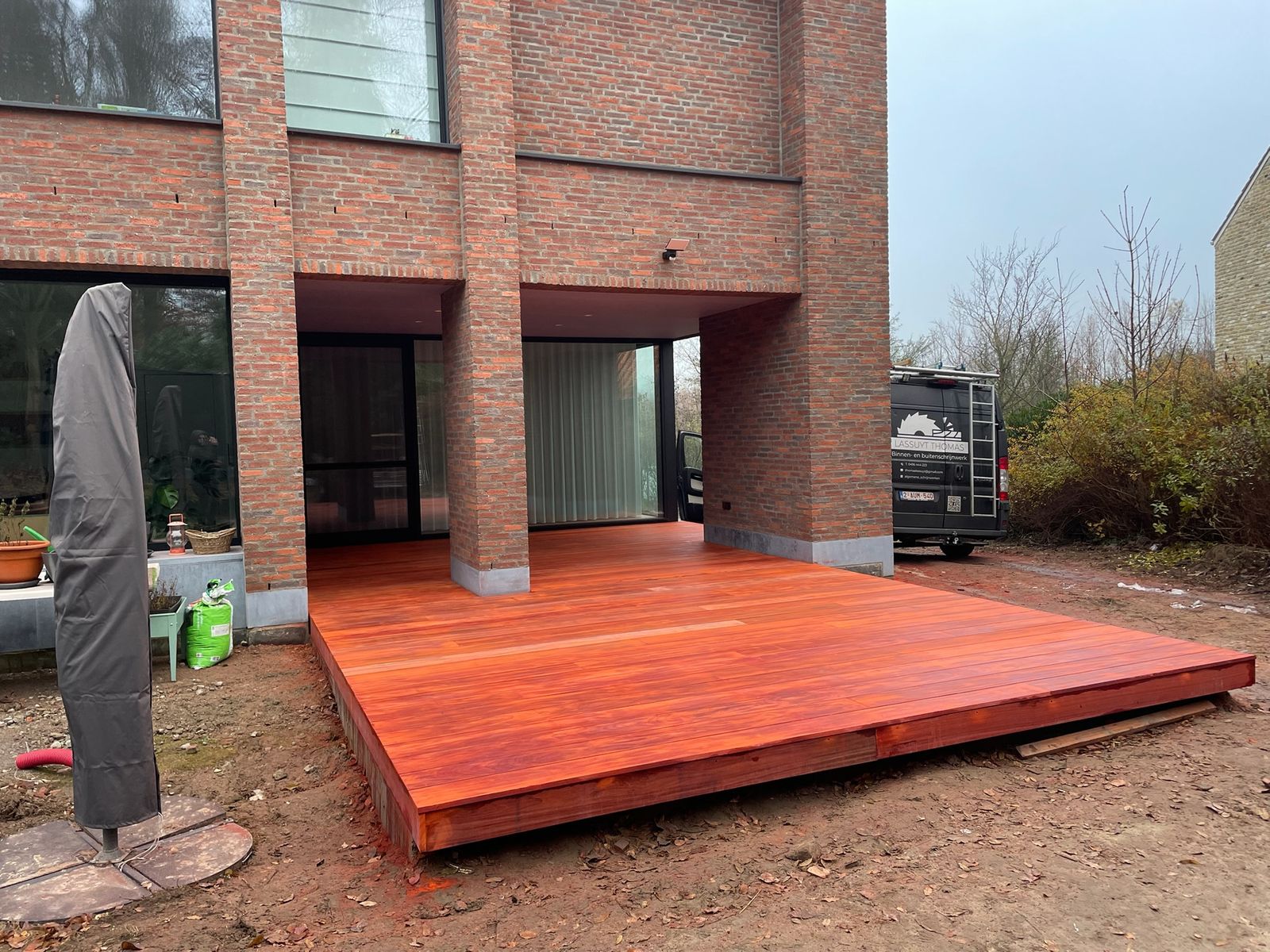 Verhoogd hardhouten terras aan de achtergevel van een nieuwbouwwoning in Bazel.