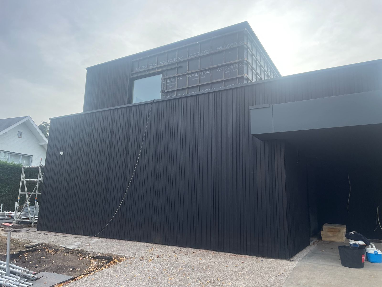 Moderne woning volledig bekleed met zwarte verticale houten gevelbekleding in Overijse.